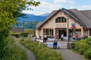 locals preparing an event outside the village hall of Épagny Metz-Tessy, surrounded by greenery and distant hills